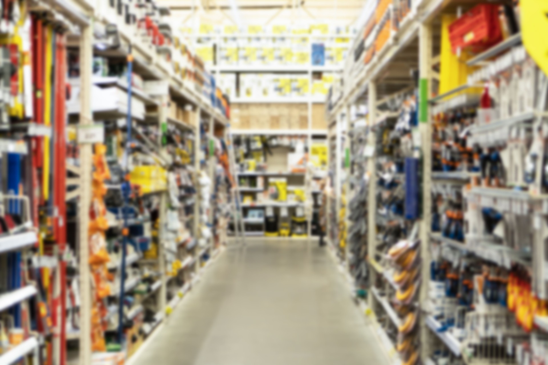 Blurred image of shelves with hand tools in a building materials hypermarket. Shopping and trading background.